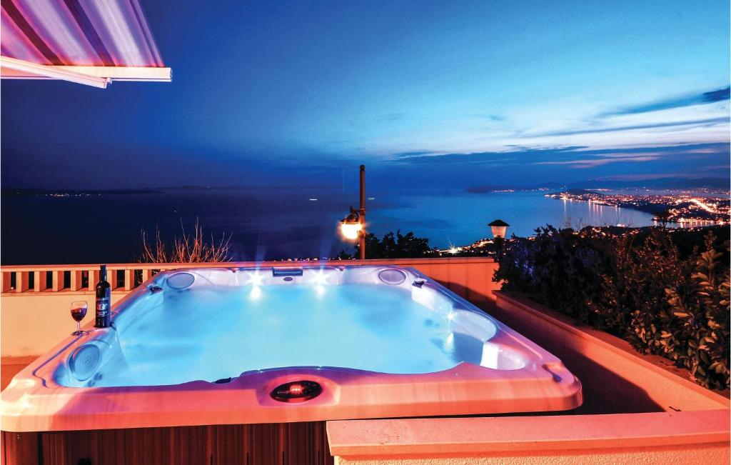 a jacuzzi tub on a balcony at night at Amazing Home In Podstrana With House Sea View in Podstrana