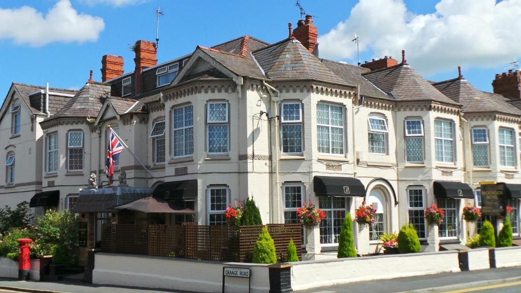 een groot wit huis met een vlag ervoor bij Brookside Hotel & Restaurant ,Suitable for Solo Travelers, Couples, Families, Groups Education trips & Contractors welcome in Chester