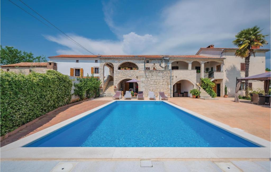 a villa with a swimming pool in front of a house at Amazing Apartment In Baderna With 3 Bedrooms, Wifi And Outdoor Swimming Pool in Baderna