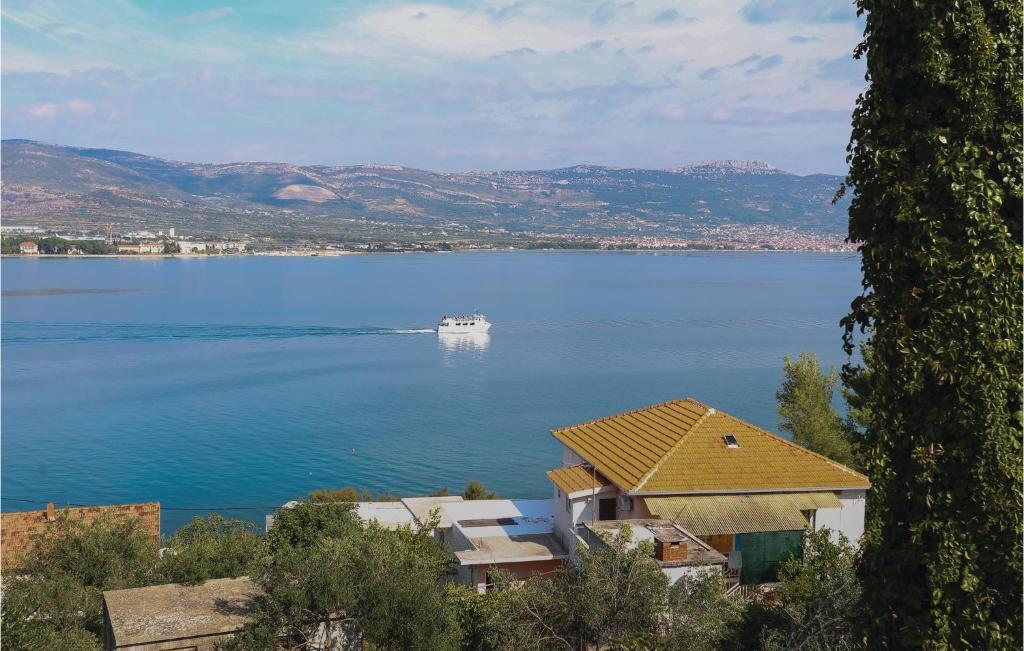 a boat in the middle of a large body of water at Stunning Apartment In Arbanija With House Sea View in Trogir