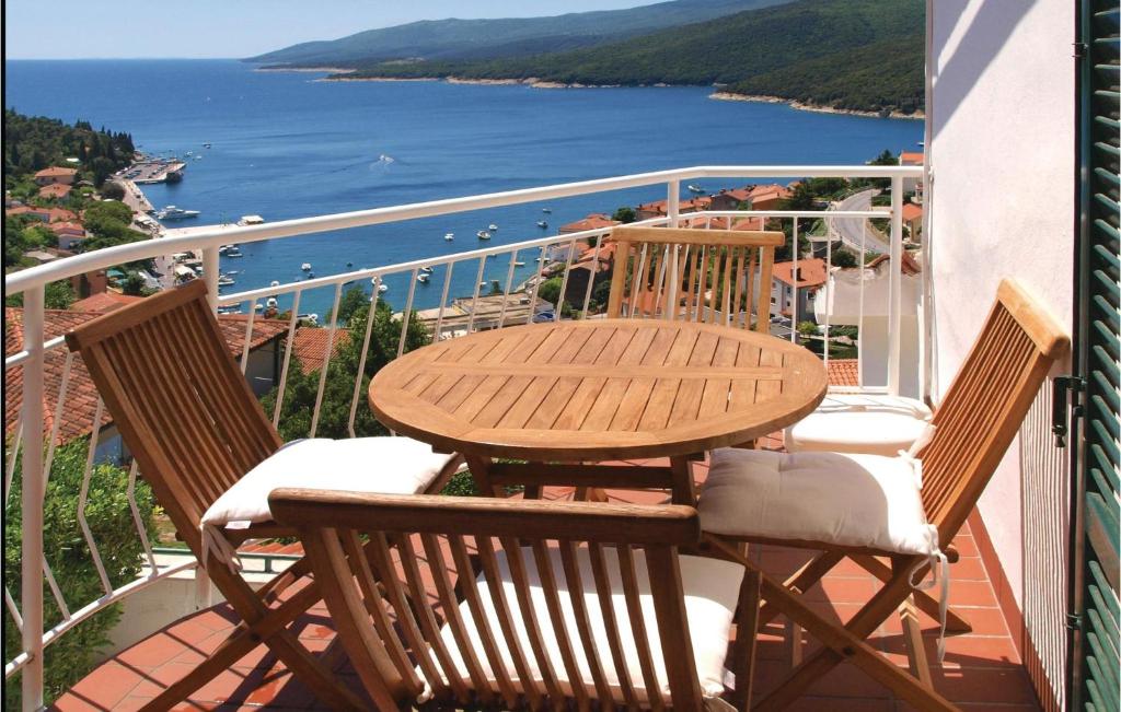 una mesa y sillas en un balcón con vistas al agua en Stunning Apartment In Rabac With 2 Bedrooms And Wifi, en Rabac