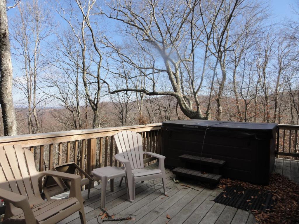 a porch with two chairs and a piano on a deck at Maple Chalet by VCI Real Estate Services in Beech Mountain