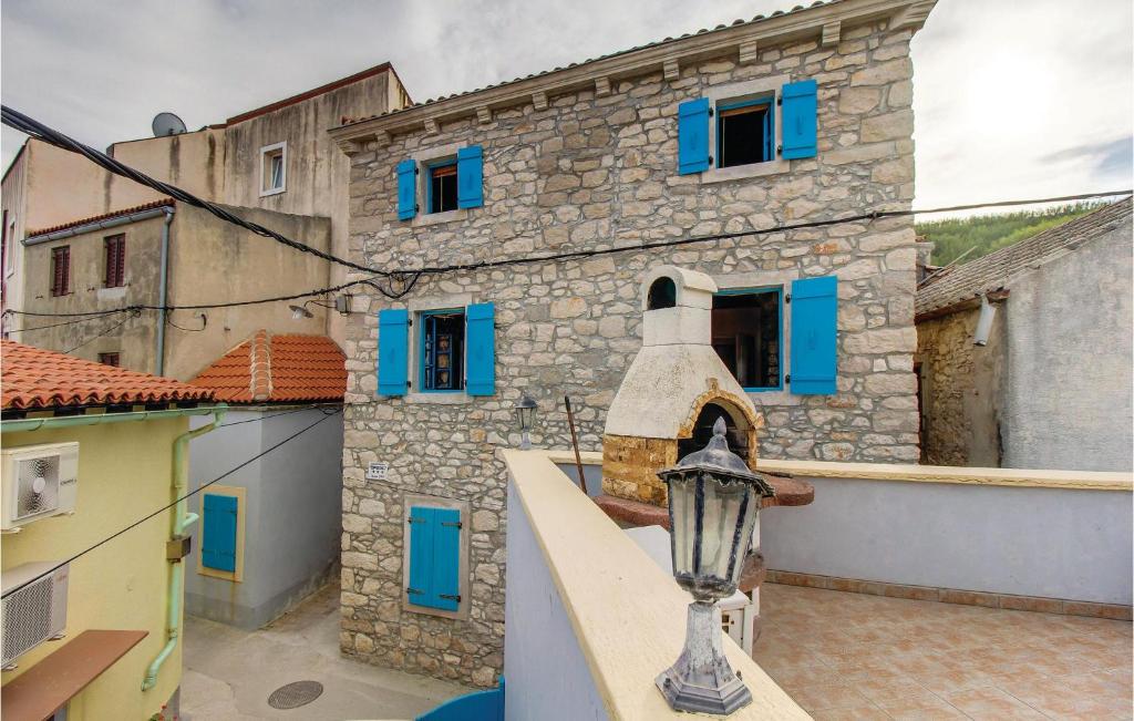 a building with blue windows and a street light at Amazing Apartment In Susak With Wifi in Susak