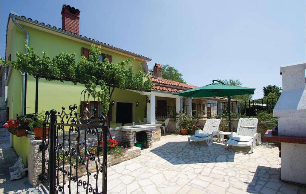 Hreljići的住宿－克羅地亞貝拉維奇度假屋，户外庭院配有两把椅子和一把遮阳伞