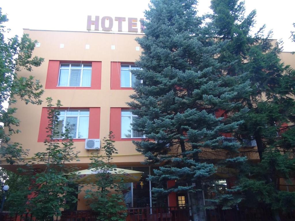 um hotel com um grande pinheiro em frente em Family Hotel Familya em Ruse