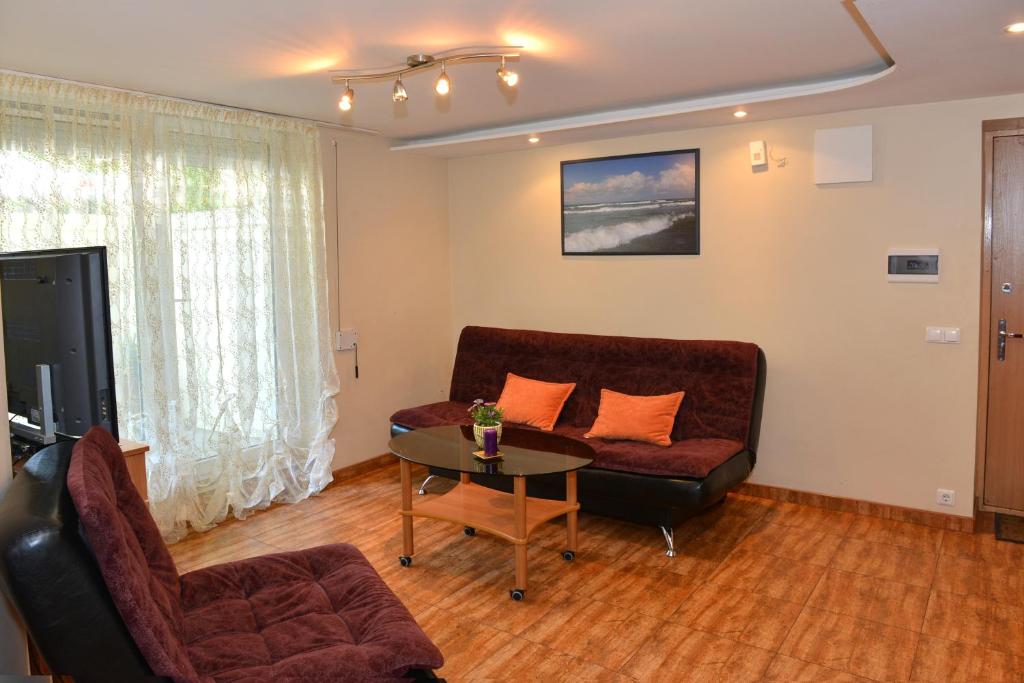 sala de estar con sofá y mesa en Kristinos Apartamentai - Vytauto, en Palanga