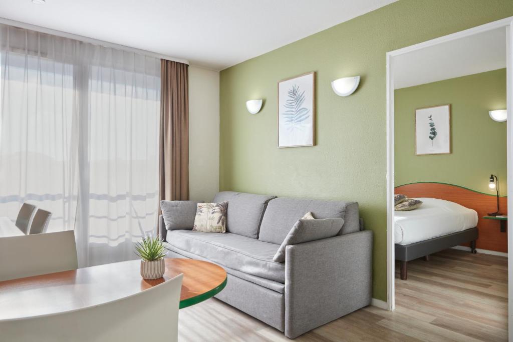 sala de estar con sofá y dormitorio en Aparthotel Adagio Access Bordeaux Rodesse en Burdeos