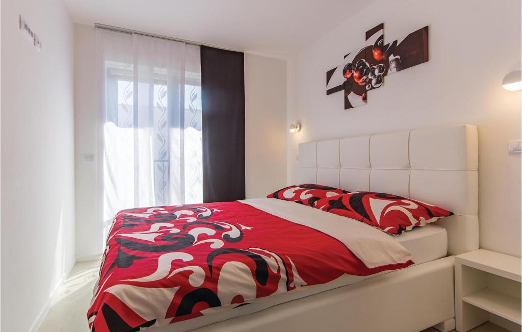 sypialnia z czerwono-białym łóżkiem i oknem w obiekcie Cozy Apartment In Medulin w Medulinie