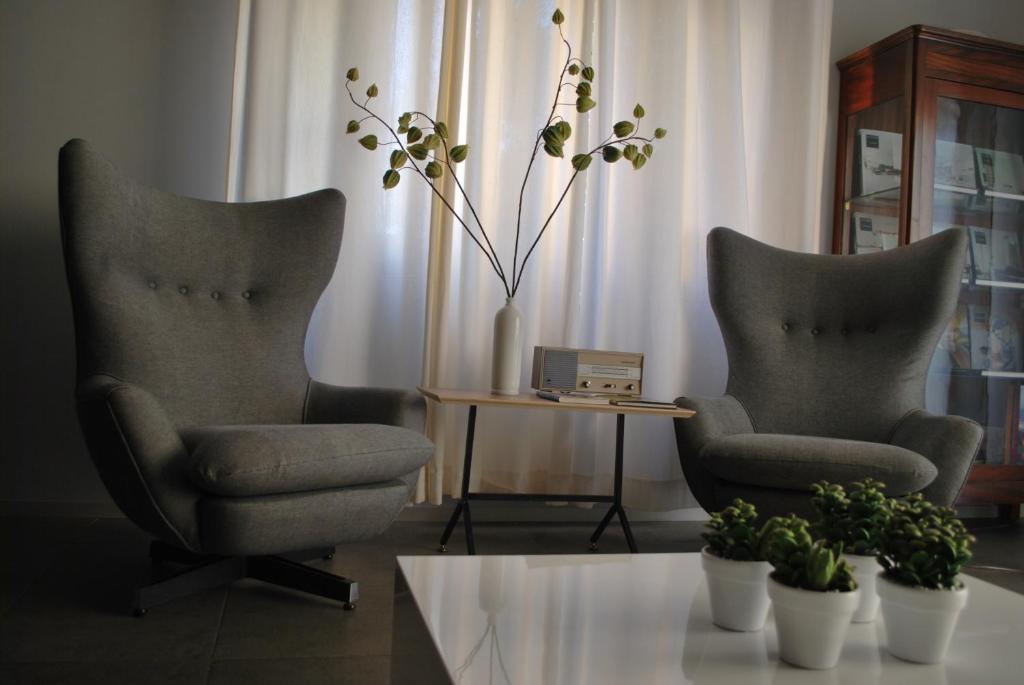 two chairs and a table in a living room at B&B Habita in Modica