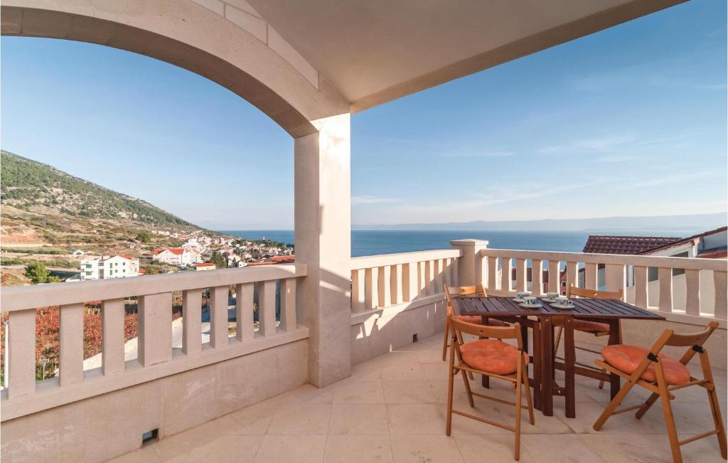 a balcony with a table and chairs and the ocean at 2 Bedroom Pet Friendly Apartment In Bol in Bol
