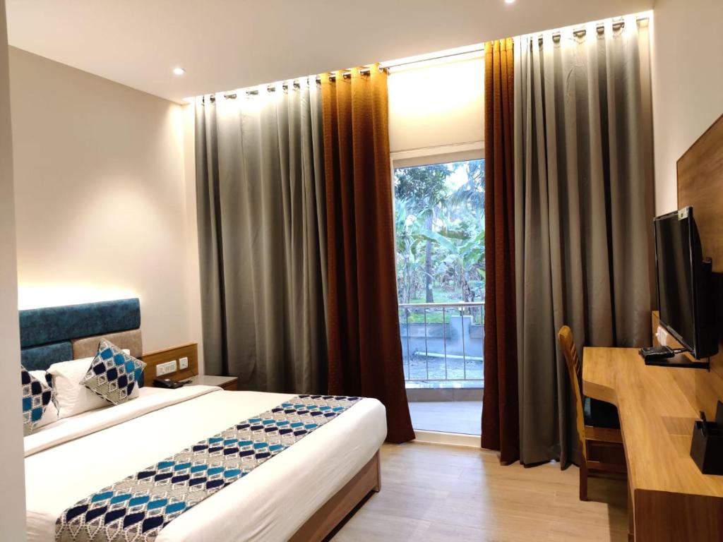 a hotel room with a bed and a window at Mermaid Resorts & Banquets in Chennai