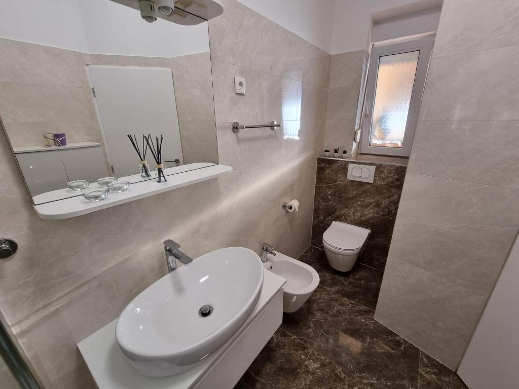 biała łazienka z umywalką i toaletą w obiekcie Apartment Paula w mieście Jadranovo