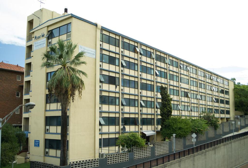 un edificio de oficinas con una palmera delante en Mountway Holiday Apartments, en Perth