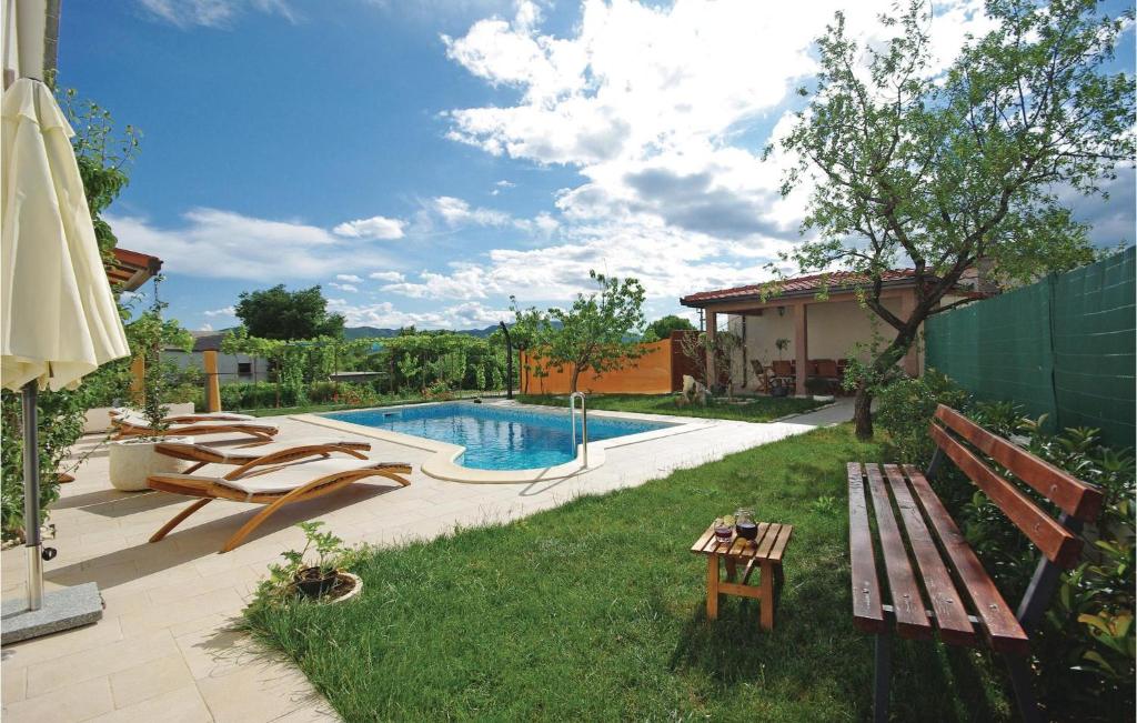 un patio trasero con una piscina con un banco y una mesa en Gorgeous Apartment In Sestanovac With Wifi, en Šestanovac