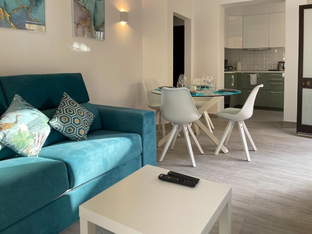 a living room with a blue couch and a table at T1 center of Marina Vilamoura in Quarteira