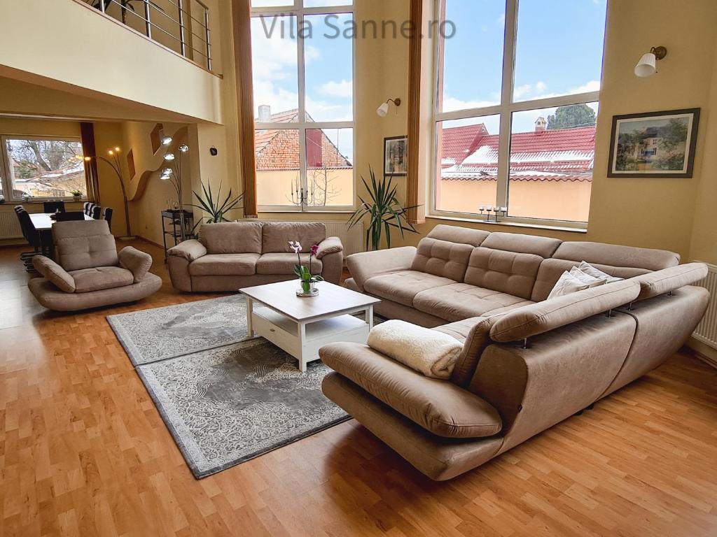 a large living room with couches and a table at Vila Sanne Brașov , Hălchiu in Heldsdorf