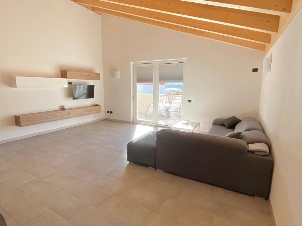 ein Wohnzimmer mit einem Sofa und einem TV in der Unterkunft Attico Bella Vista in Dubino