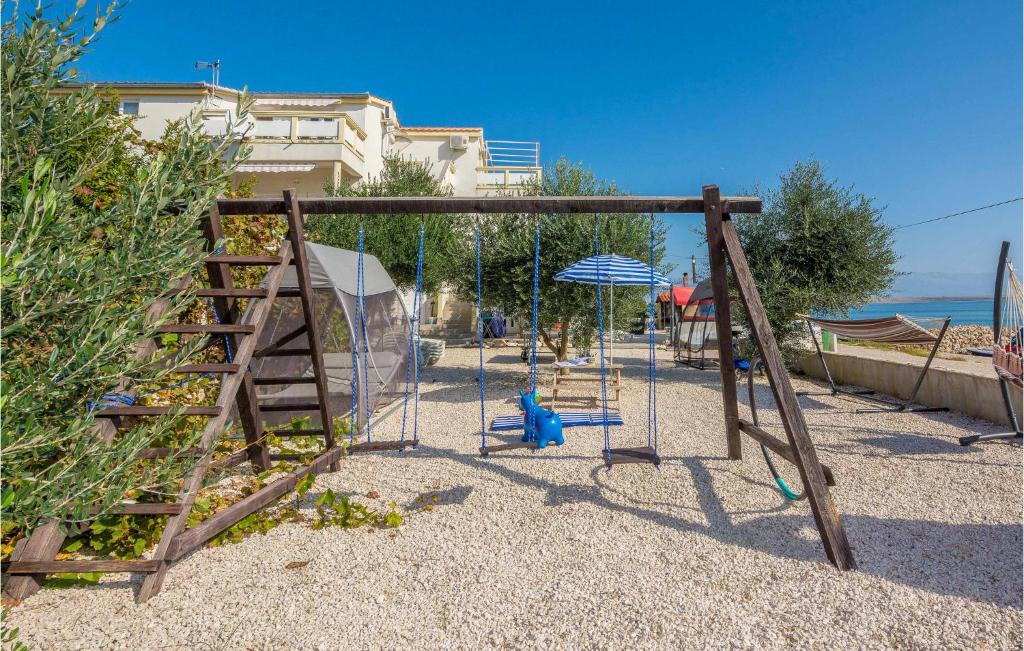 an empty playground with swings and an umbrella at Gorgeous Apartment In Vir With House Sea View in Vir