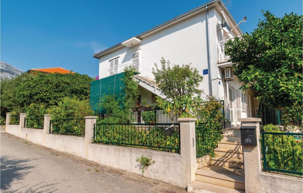 a white house with a fence at 2 Bedroom Pet Friendly Apartment In Orebic in Orebić