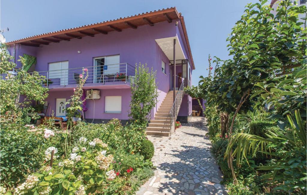 uma casa roxa com escadas que levam até ela em Gorgeous Apartment In Fazana With Kitchen em Fažana