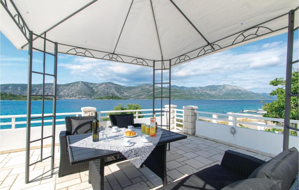 a patio with a table and chairs and a view of the water at Awesome Apartment In Racisce With Kitchenette in Račišće