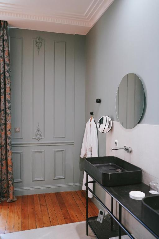 a bathroom with a black sink and a mirror at Hôtel Singulier Bordeaux - Boutique Hôtel & Spa Anne Semonin in Bordeaux