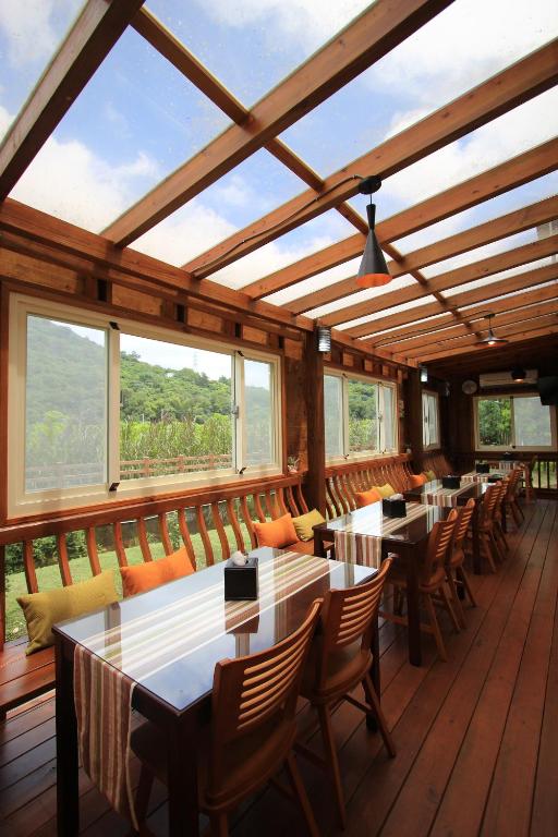 a dining room with tables and chairs and windows at Cai Feng B&amp;B in Ji&#39;an