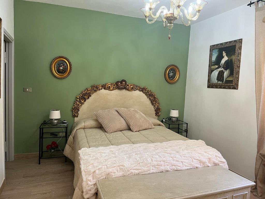a bedroom with a large bed and a chandelier at Affittacamere Il Piccolo Borgo Foligno in Foligno