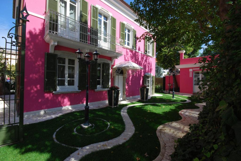 różowy budynek z drogą przed nim w obiekcie Malö Suites w mieście SantʼEgidio alla Vibrata