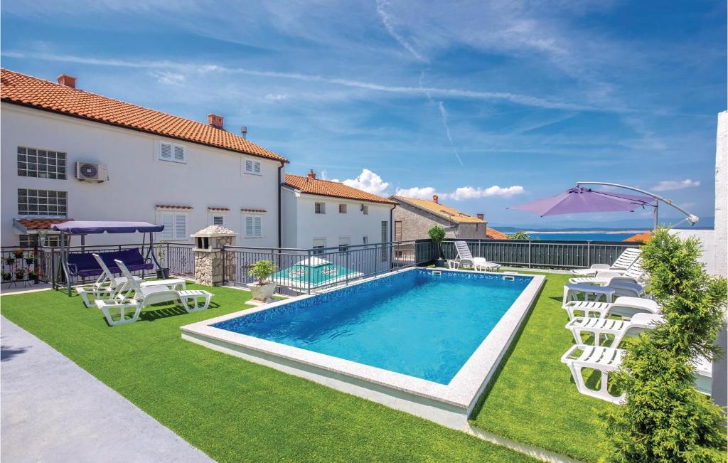 a backyard with a swimming pool and lawn with white chairs at Awesome Apartment In Crikvenica With House A Panoramic View in Crikvenica