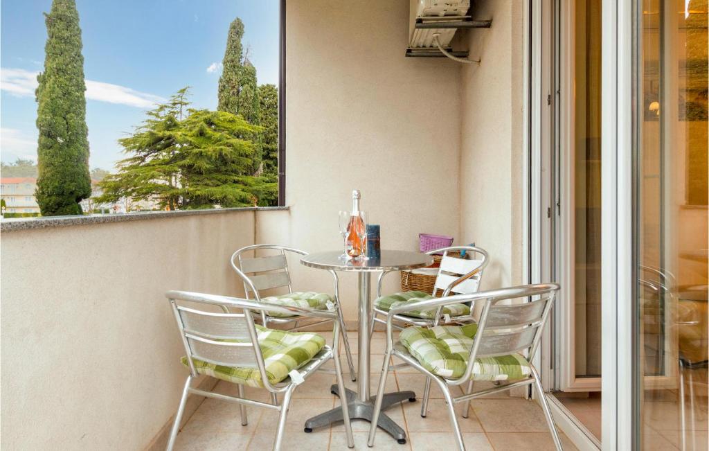 uma varanda com uma mesa e cadeiras e uma janela em Beautiful Apartment In Fazana With Wifi em Fažana