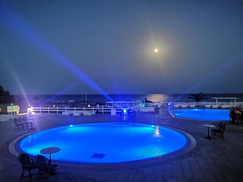 ケリビアにあるCap Bon Kelibia Beach Hotel & Spaの青い照明付きのスイミングプール