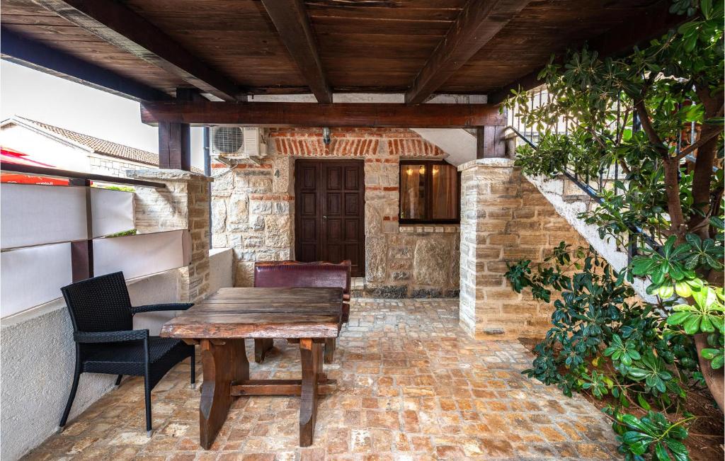 - patio z drewnianym stołem i krzesłami w obiekcie Five-Bedroom Holiday Home In Vir w mieście Vir