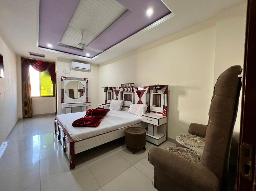 - une chambre avec un lit et un canapé dans l'établissement Hotel Continental, à Islamabad