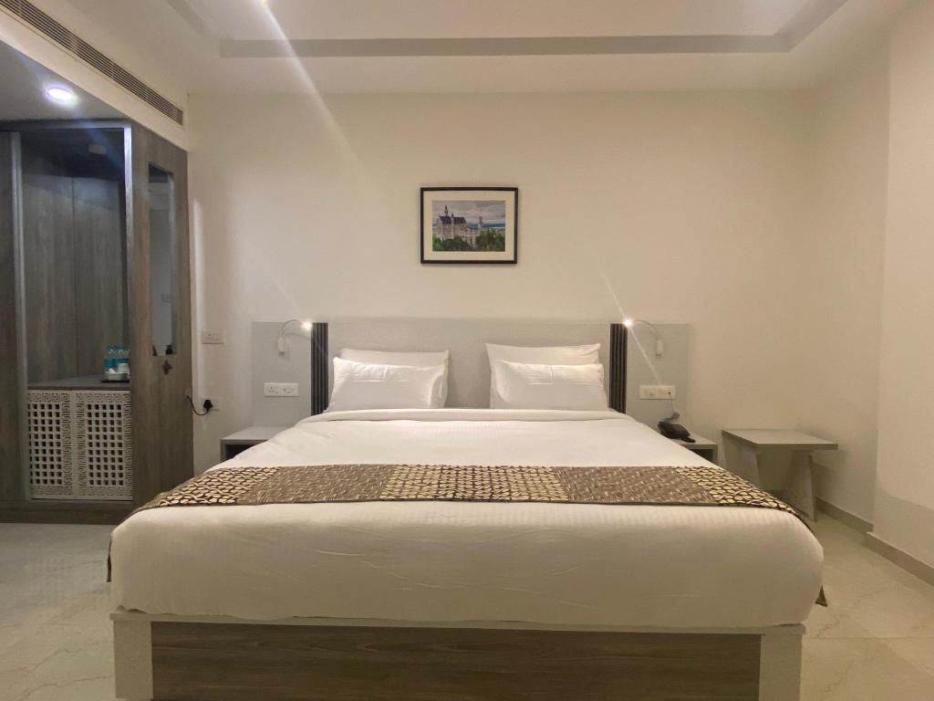 a bedroom with a large white bed with two pillows at Dash Hotels - Affordable Luxury in Hyderabad