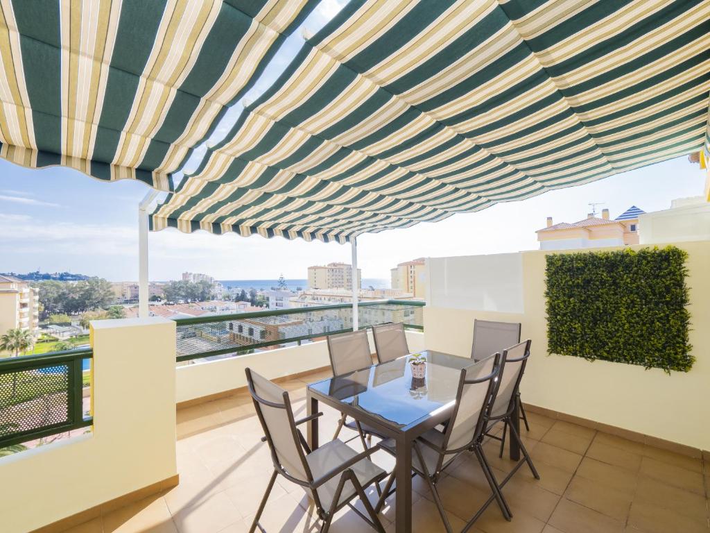 een eetkamer met een tafel en stoelen op een balkon bij Cubo's La Terraza del Mar in Algarrobo