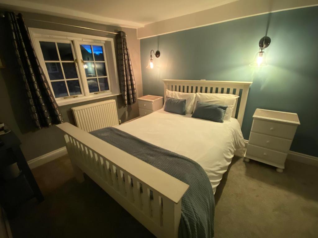 een slaapkamer met een wit bed en een raam bij The Carriers Arms in Codford Saint Mary