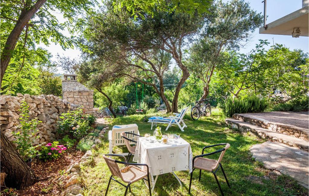 een tafel en stoelen in een tuin met bomen bij Nice Apartment In Vinjerac With Kitchen in Vinjerac