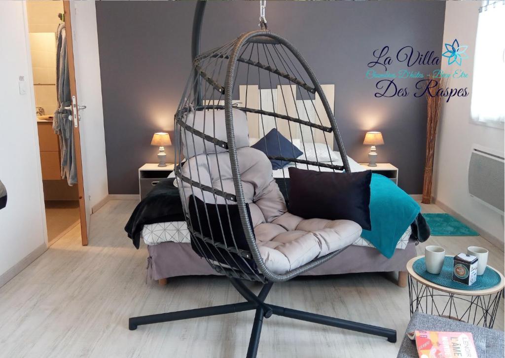 ein Zimmer mit einem Schaukelstuhl in einem Zimmer in der Unterkunft La Villa Des Raspes - Holistique Spa - Adult Only in Viala-du-Tarn