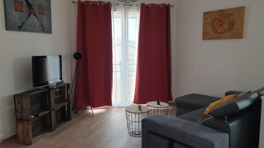 ein Wohnzimmer mit einem Sofa und einem TV in der Unterkunft Lhacienda in Marseille