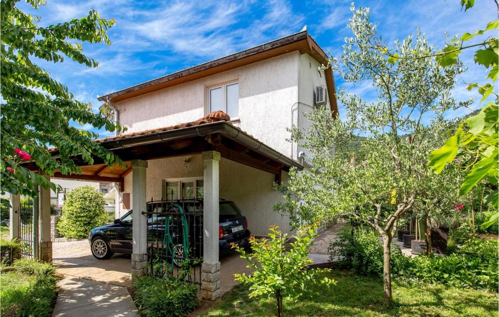 a house with a car parked in front of it at Beautiful Apartment In Rukavac With Wifi in Rukavac