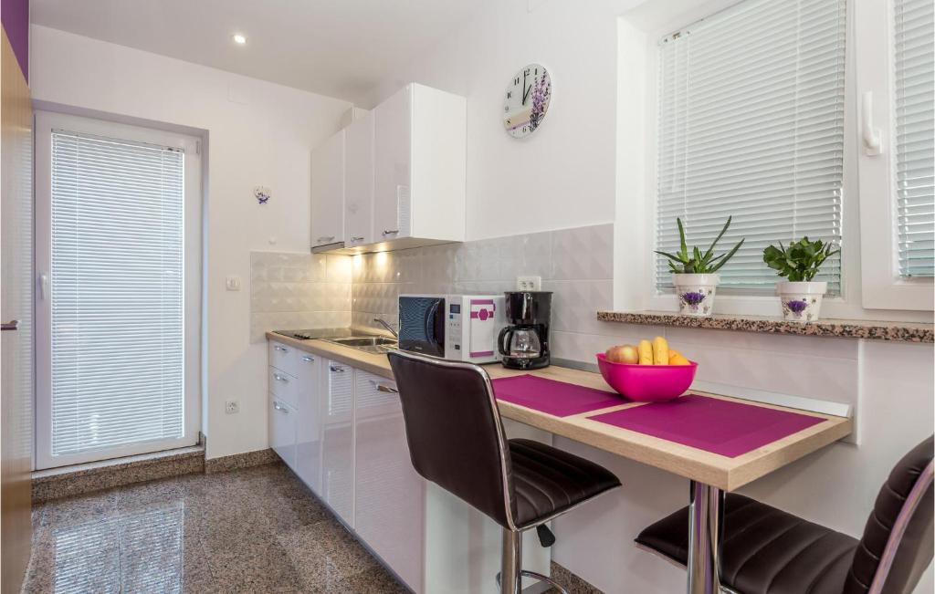 a kitchen with a table with a bowl of fruit on it at Beautiful Apartment In Rukavac With Wifi in Rukavac