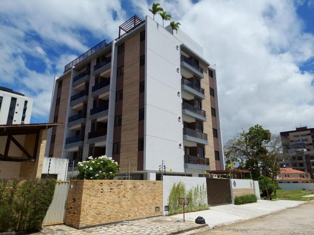a building with a tree on the top of it at Flat Siberian 100m do mar in Cabedelo