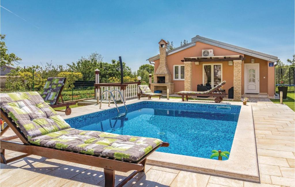 a swimming pool with a chair and a house at Gorgeous Home In Pula With Outdoor Swimming Pool in Valtura