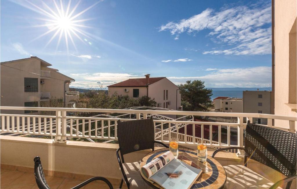 a balcony with a table with a laptop on it at Cozy Apartment In Makarska With Kitchen in Makarska
