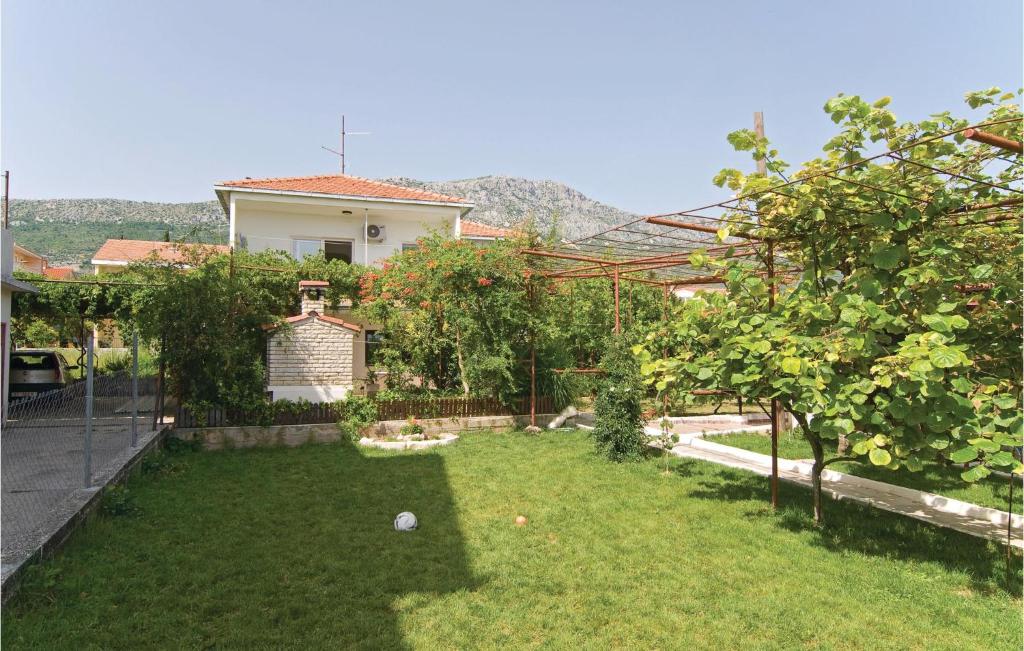 a backyard with a yard with trees and a house at 3 Bedroom Beautiful Apartment In Kastel Kambelovac in Kaštela