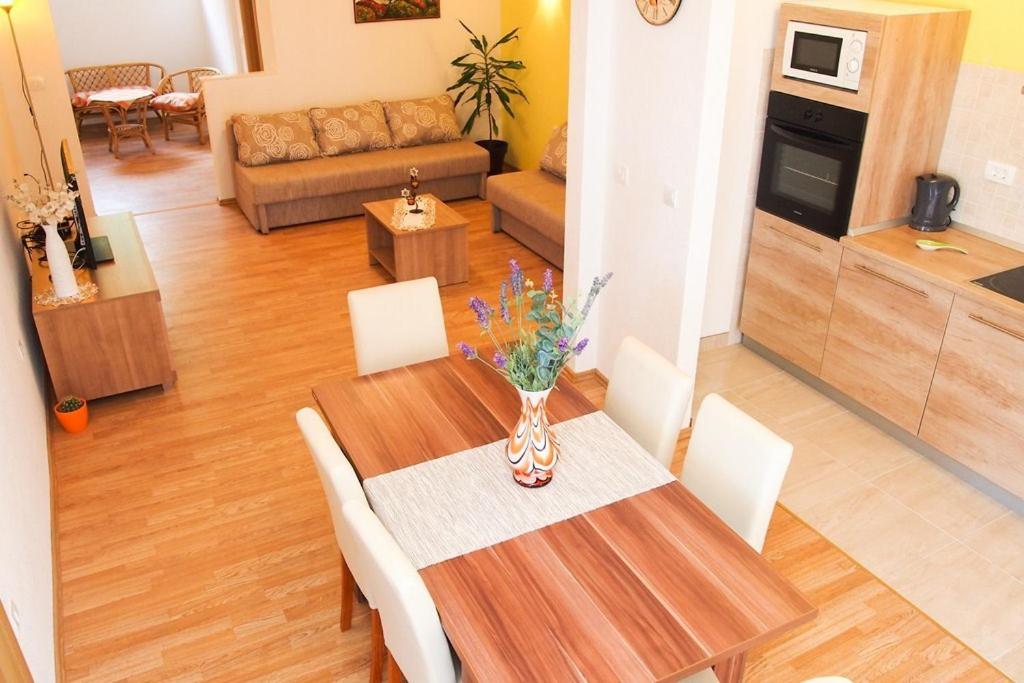 a dining room table with white chairs and a living room at Apartment Anna Maria in Promajna