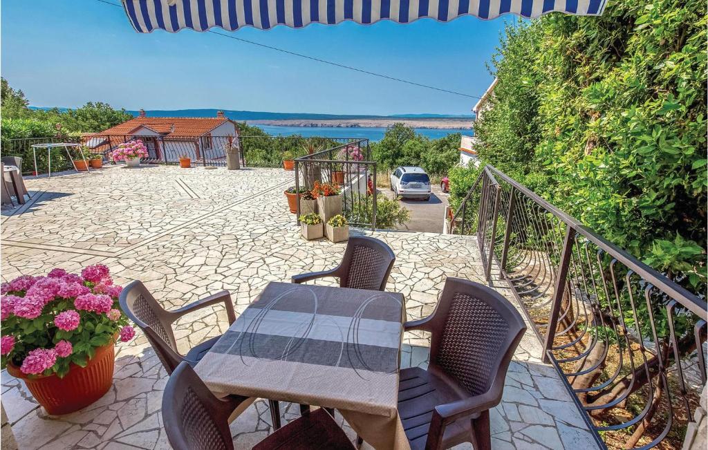 un patio con mesa, sillas y flores en Lovely Apartment In Jadranovo With Wifi en Jadranovo