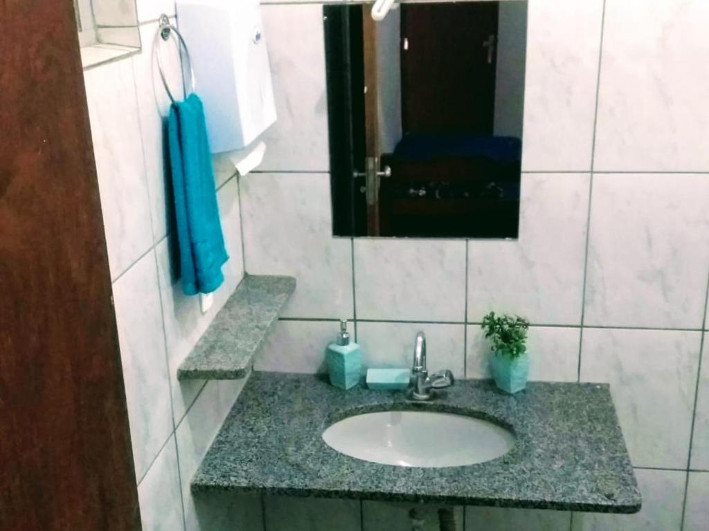 y baño con lavabo y espejo. en Pousada Recanto Dos Tucanos en Capitólio