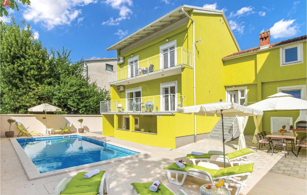 ein gelbes Haus mit einem Pool davor in der Unterkunft 5 Bedroom Cozy Home In Pula in Pula